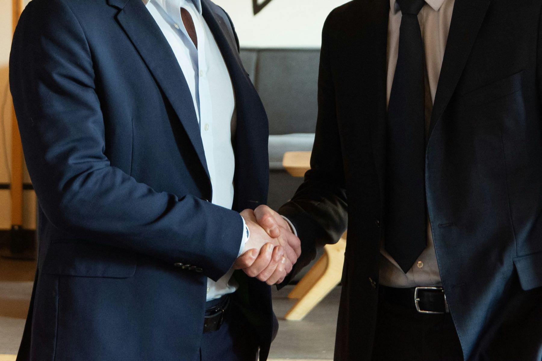 Two business professionals in suits shaking hands